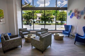 Relax in a spacious waiting area with a large window offering a clear view of the street outside. Enjoy comfortable seating and a central coffee table.
