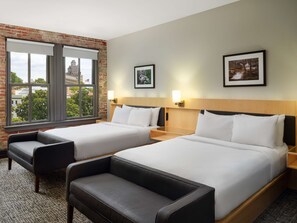 Relax in this stylish room with two single beds, a comfortable seating area, and a city view.
