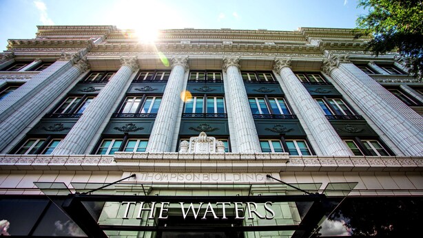 A classical building with large columns and a sign reading "THE WATERS". - The Waters Hot Springs, Tapestry Collection by Hilton (Hot Springs)