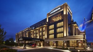 A modern hotel with a prominent 'Lodge Kohler' sign, large windows, and a well-lit entrance.