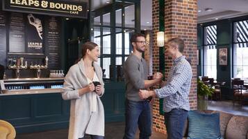 A café interior with a bar area, seating, and a brick accent wall.