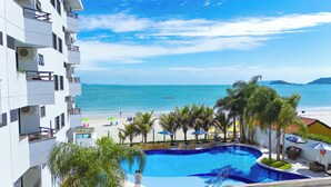 A hotel with a pool, beach view, and palm trees. - Hotel Palace 1 (Florianópolis)