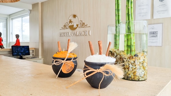 A hotel reception area with a sign reading "HOTEL PALACE," decorative vases with natural elements, and a computer monitor in the background. - Hotel Palace 1 (Florianópolis)