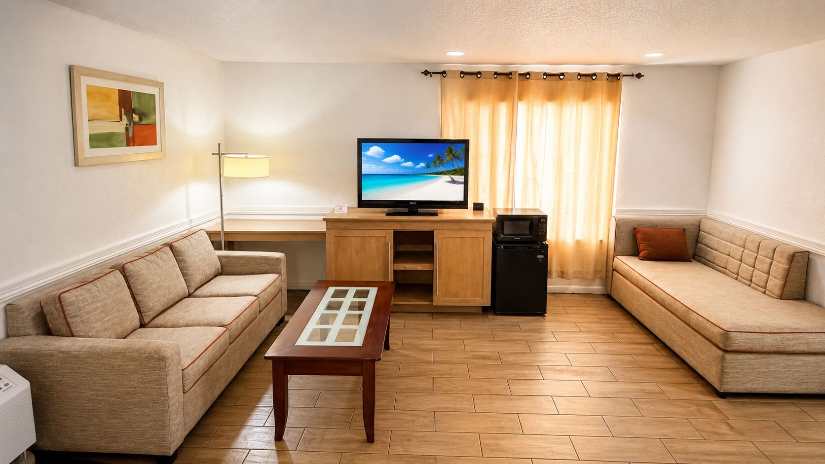 A living room with a sofa, a coffee table, a television, and a refrigerator.