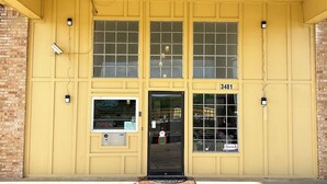 A yellow building with a black door, numbered 3401, and a 'VACANCY' sign on the window.