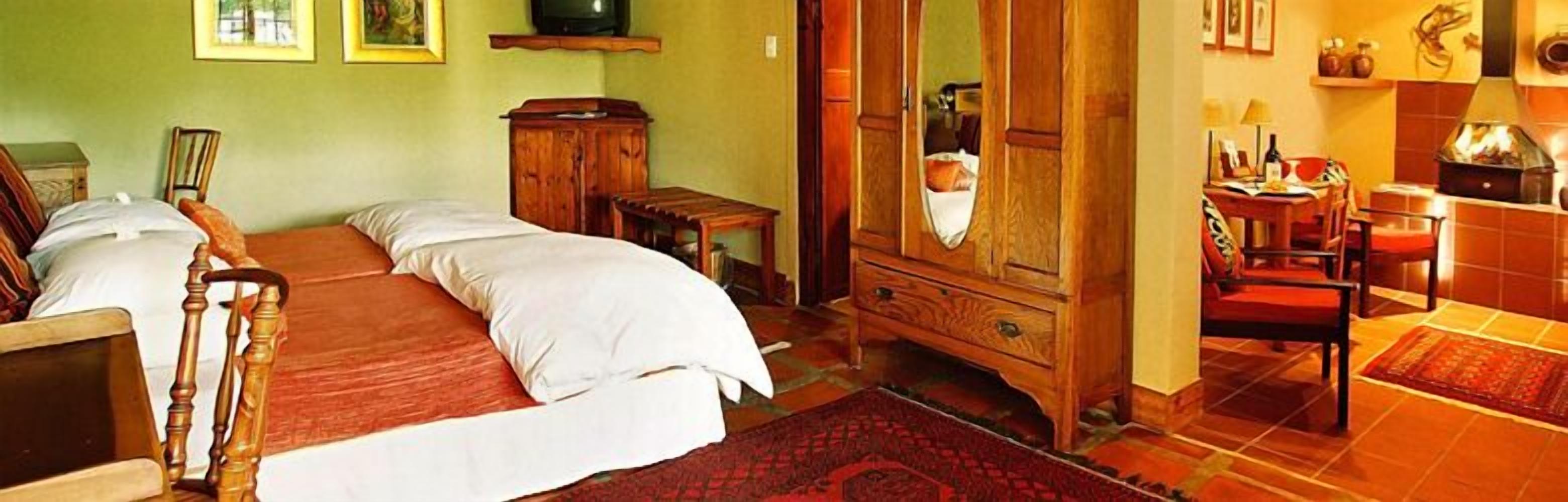 A bedroom with a large bed, wooden wardrobe, and a small table.