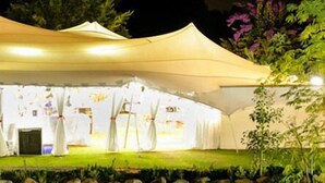 A large, illuminated tent structure with a flat roof and multiple entry points. - De Opstal (Oudtshoorn)