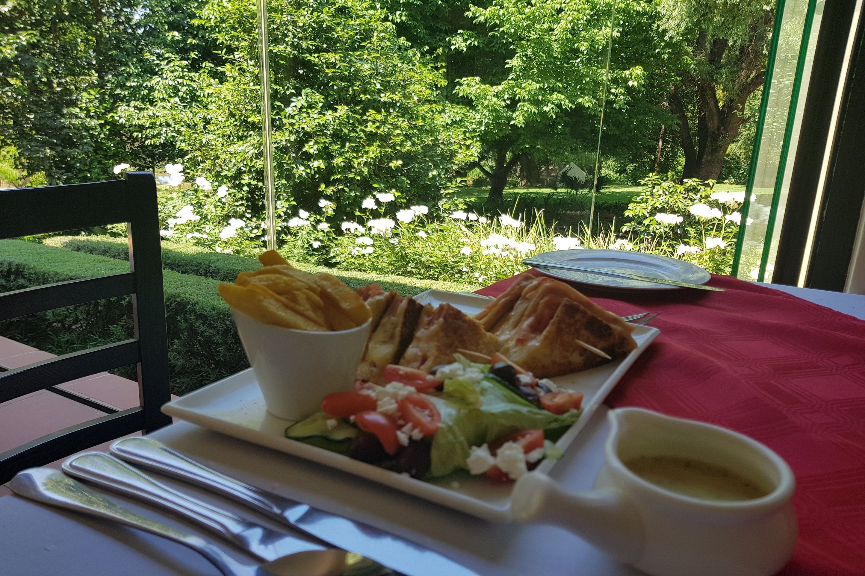 Una mesa de comedor con un plato de comida, una taza y un tenedor.