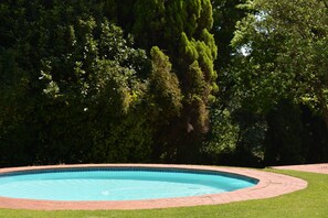 Alberca al aire libre, sombrillas en la alberca y camastros 