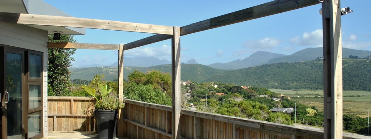 A wooden deck with a view of a mountainous landscape.