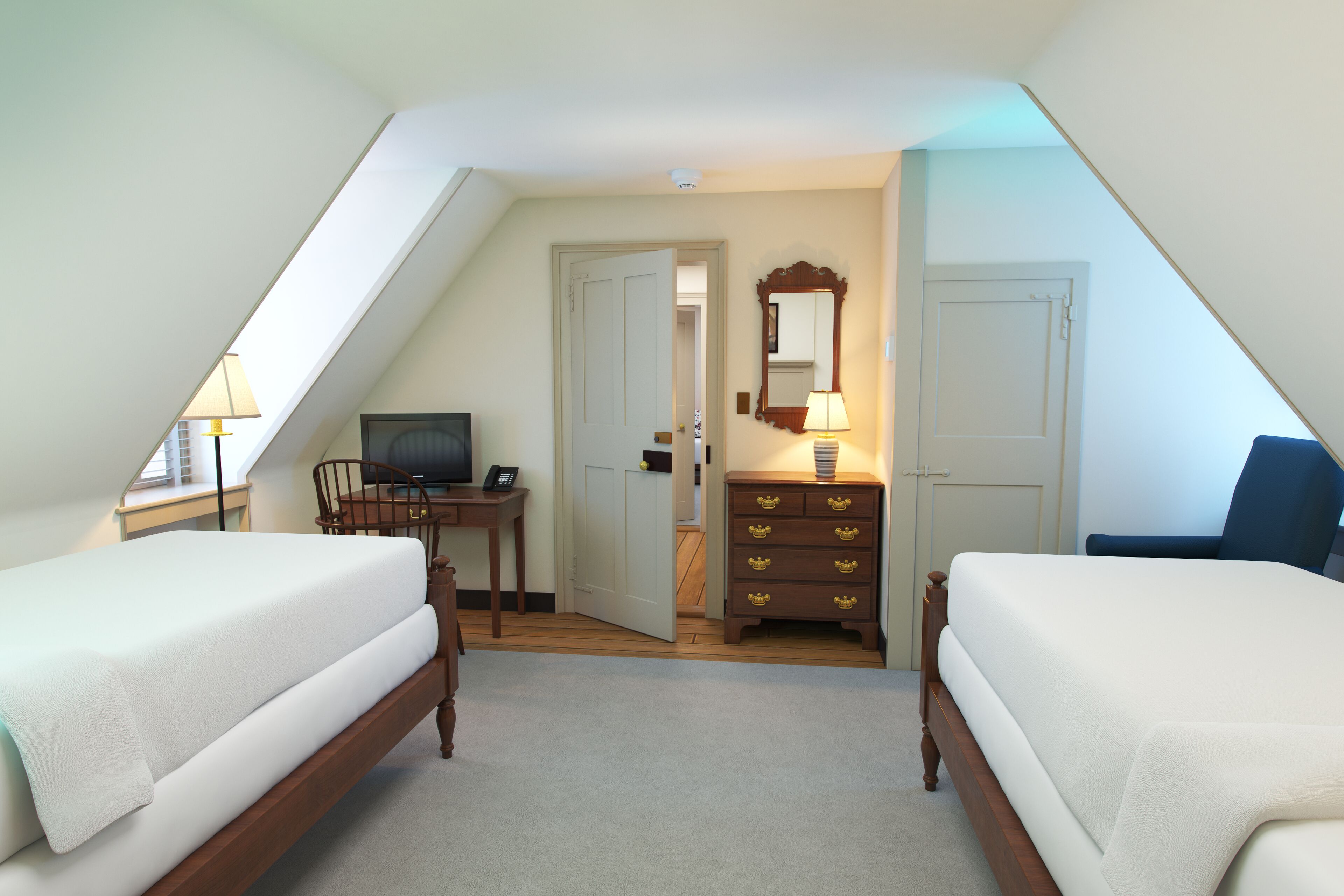 A bedroom with two beds, a desk with a computer, a dresser, and a mirror.
