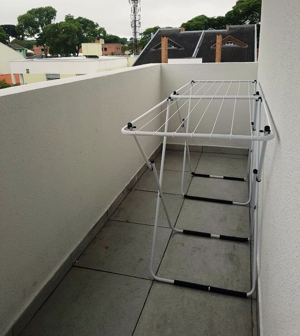 A balcony with a white metal drying rack.