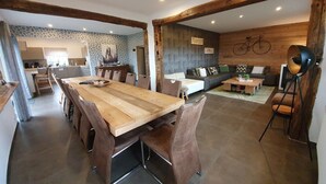 A modern interior with a wooden dining table, brown leather chairs, a sofa, and a bicycle wall decoration. - Villa with Spa-Francorchamps F1 Circuit (Francorchamps (Stavelot))