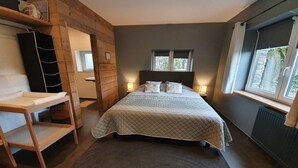 A bedroom with a bed, bedside lamps, a wooden shelf, and a window with curtains. - Villa with Spa-Francorchamps F1 Circuit (Francorchamps (Stavelot))