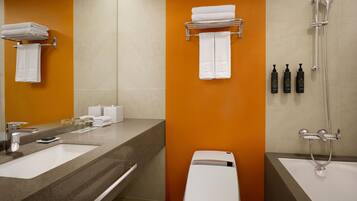 Une salle de bain moderne avec un grand miroir, deux lavabos, des toilettes et une douche.
