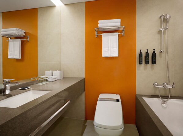 Un baño moderno con un espejo grande, dos lavamanos, un inodoro y una ducha.