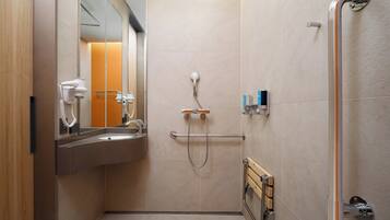 A modern bathroom with a sink, mirror, and shower.