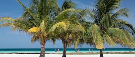 On the beach, white sand, sun-loungers, beach towels