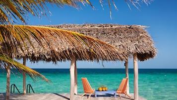 On the beach, white sand, sun loungers, beach towels