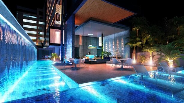 Ett modernt hotell med pool, utomhusservering och en bar.