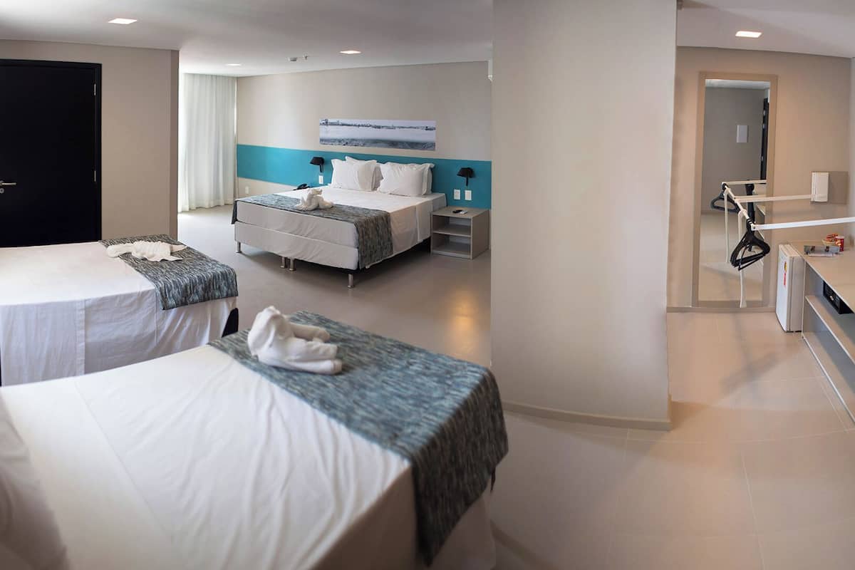 Une chambre d’hôtel avec deux lits, un bureau et une salle de bain.