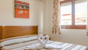 A hotel room with a bed, a painting on the wall, and a window with curtains. - Tesy II (LA MANGA)