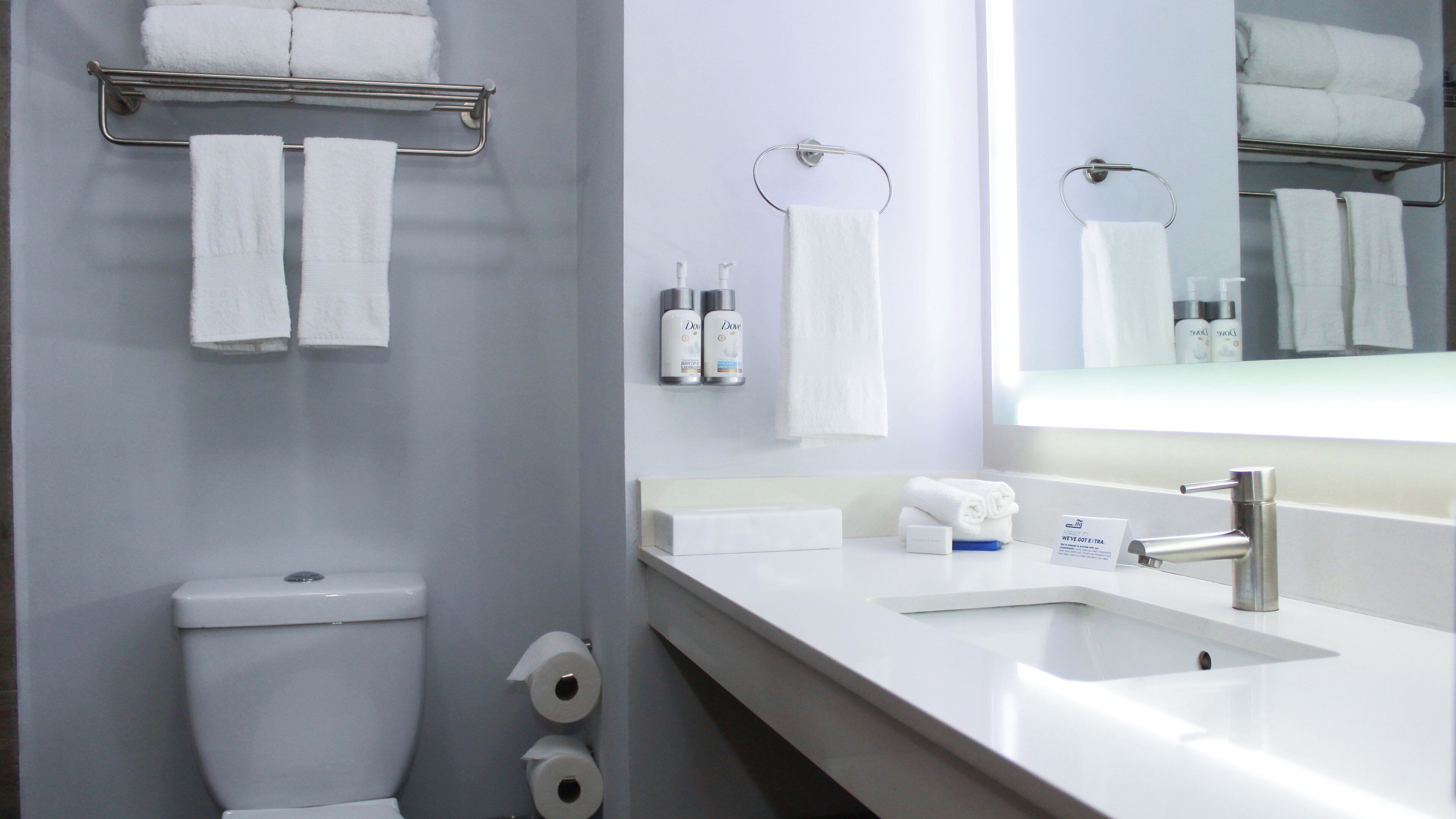 A modern bathroom with a toilet, sink, and towel rack.