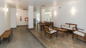 A hotel lobby with a reception desk, seating area, and a fire extinguisher.