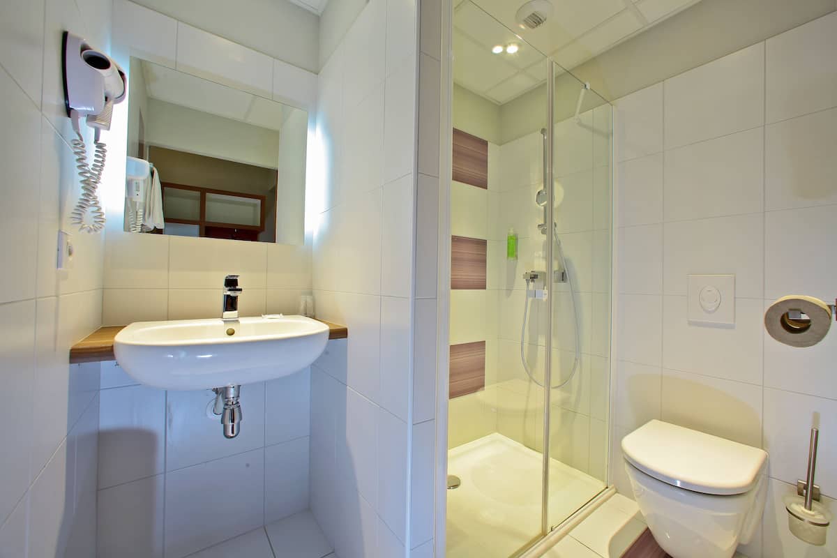 standard twin room | bathroom | shower, eco-friendly toiletries, hair dryer, towels