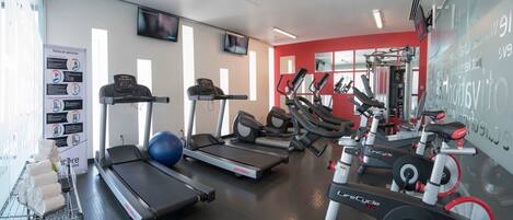 A gym with treadmills, elliptical machines, and weight equipment.