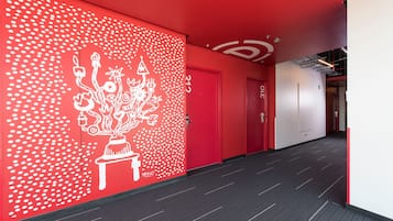 A modern hallway with red walls and a white dot pattern design.