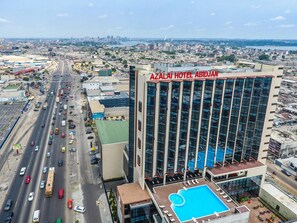A high-rise hotel with a rooftop pool and a view of the cityscape. - Azalai Hôtel Abidjan (Abidjan)