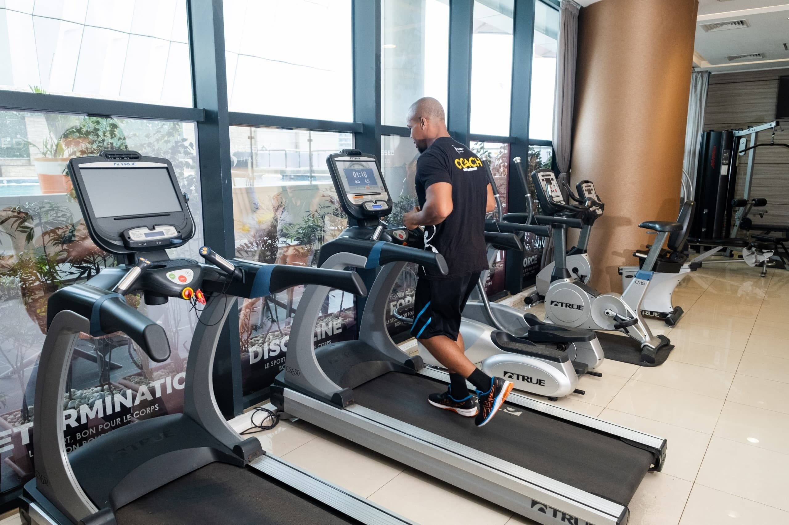 Uma academia com esteiras e equipamentos de ginástica.