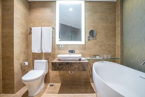A modern bathroom with a toilet, sink, and bathtub. - Ashley Wahid Hasyim Jakarta (Jakarta)