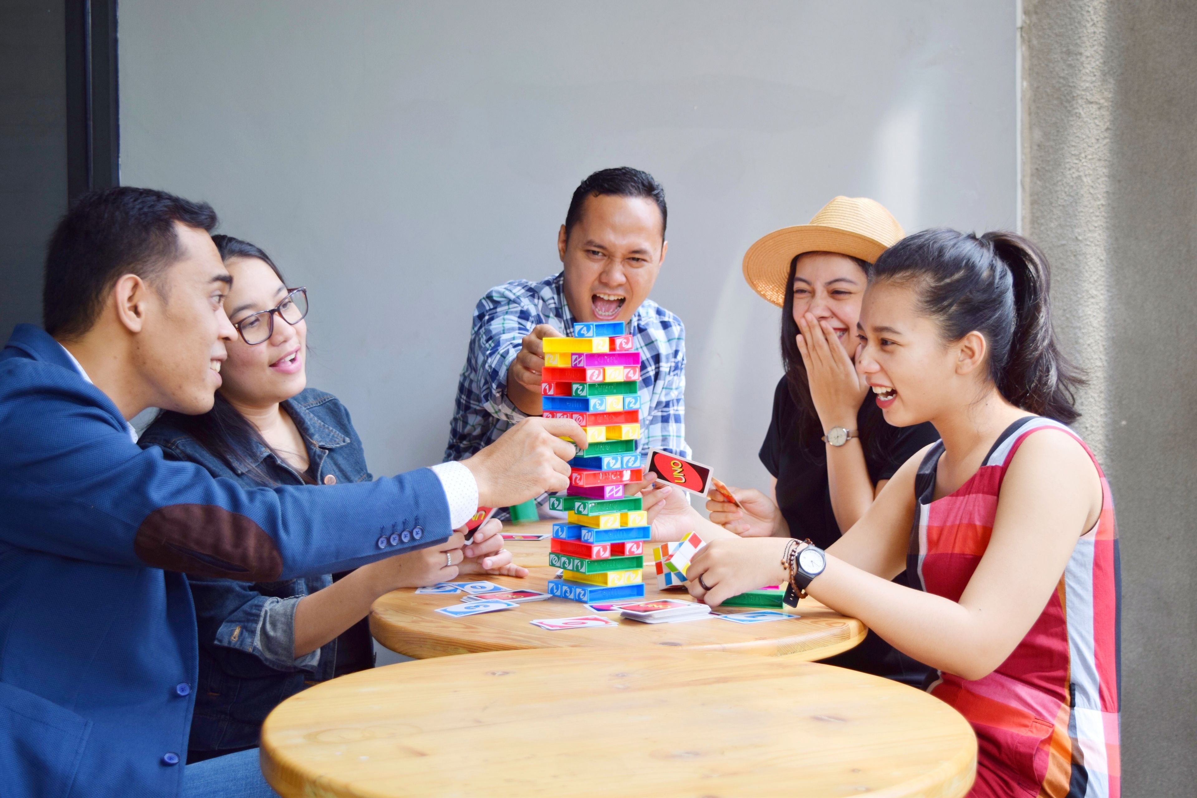 A group of people playing a game at a wooden table.