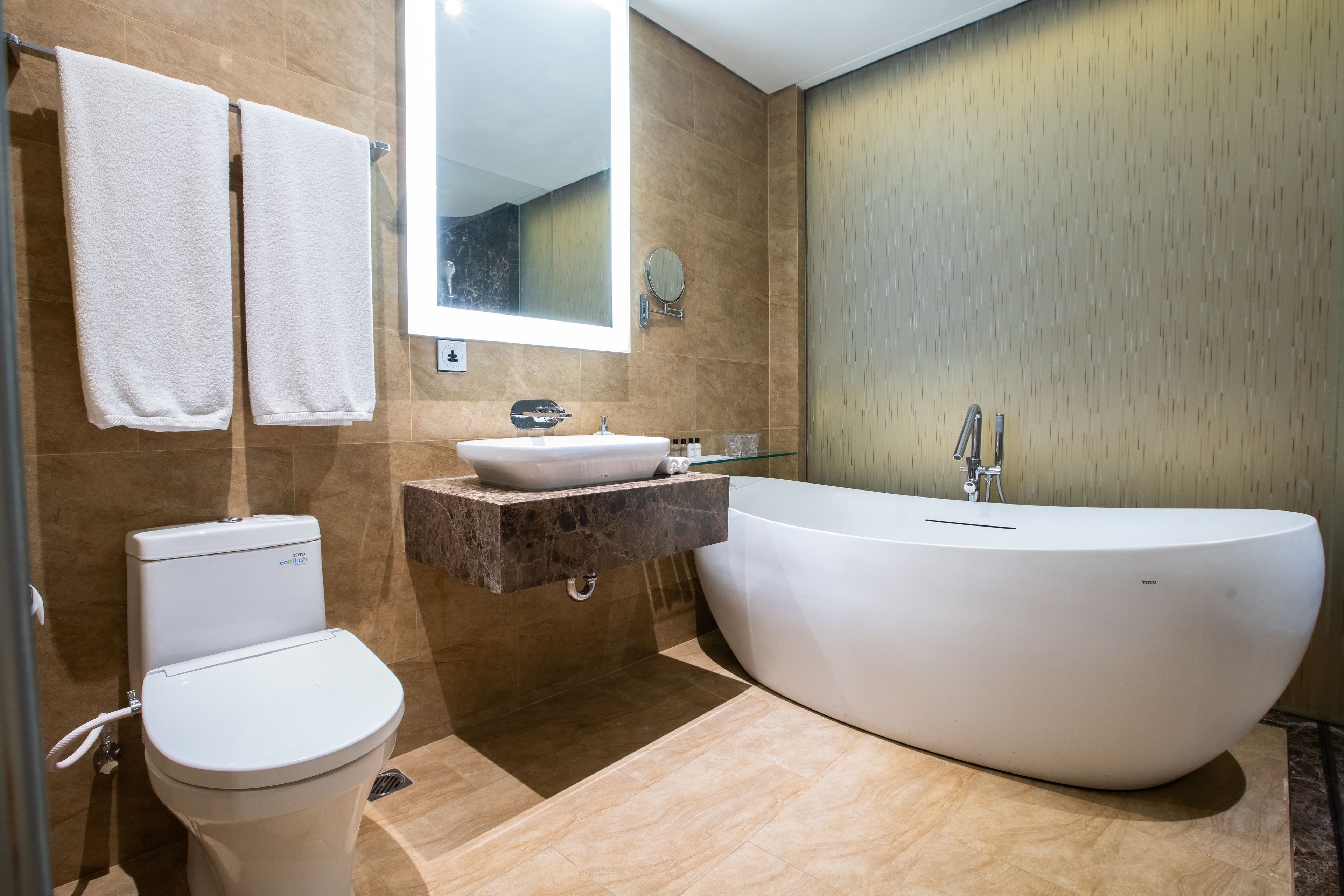 A modern bathroom with a freestanding bathtub, a toilet, and a vanity with a sink.