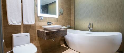 A modern bathroom with a freestanding bathtub, a toilet, and a vanity with a sink.