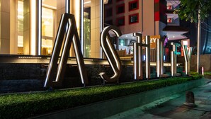 A modern building with large illuminated letters spelling "ASHLEY" on the facade. - Ashley Wahid Hasyim Jakarta (Jakarta)