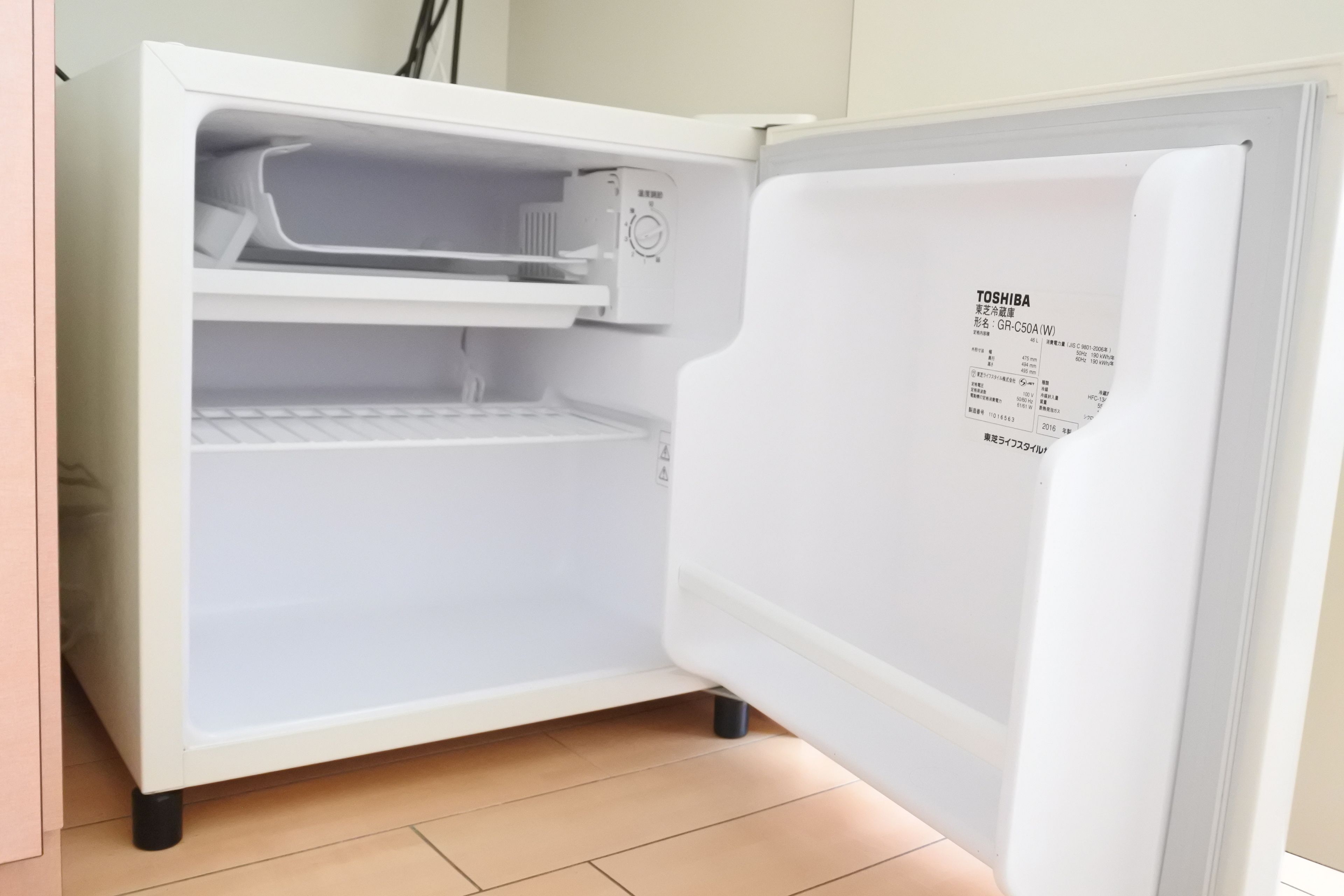 A white refrigerator with a control panel and a label on the door.