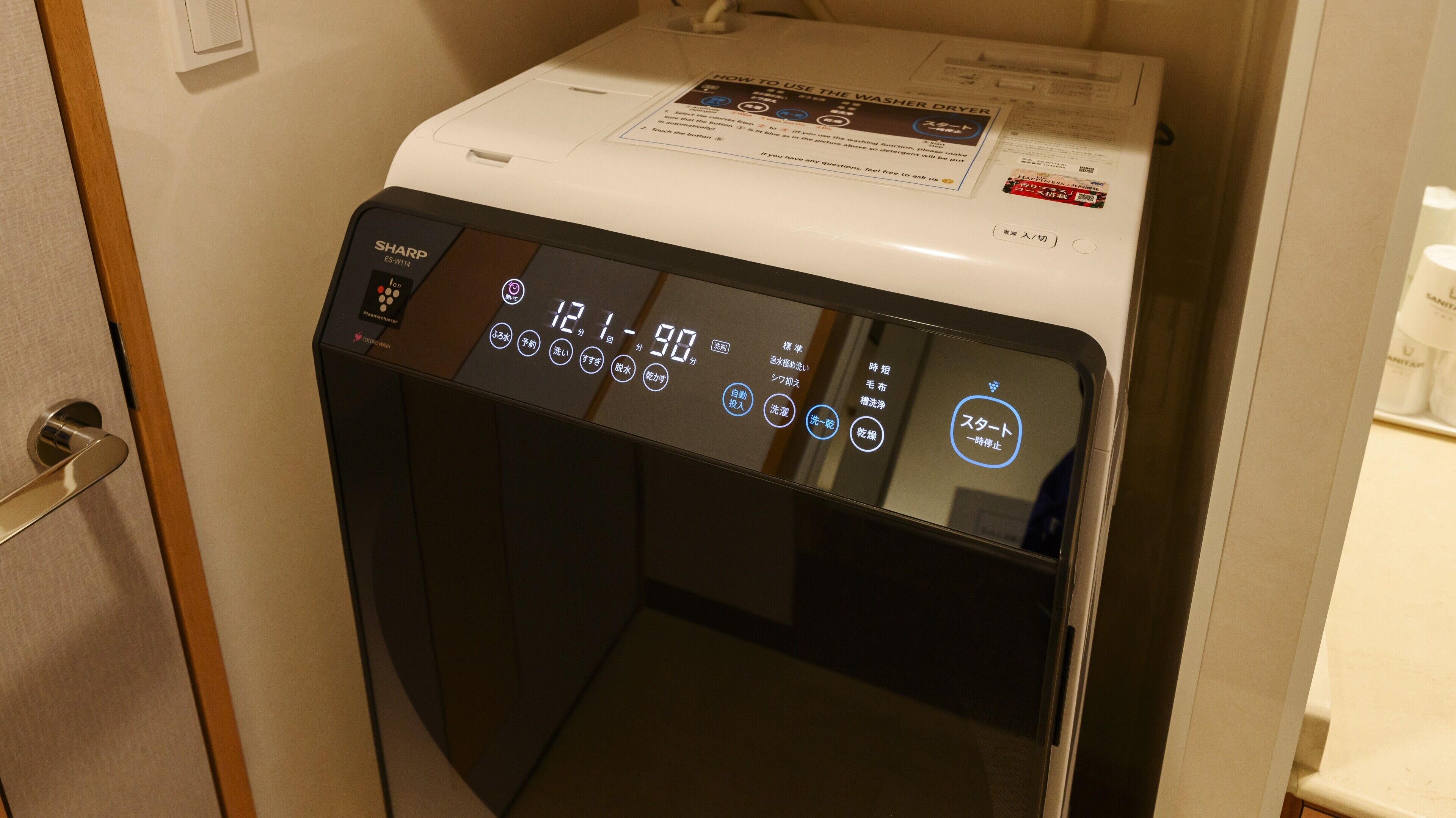 Eine Sharp Waschmaschine mit Frontlader, digitalem Display und Bedienfeld.