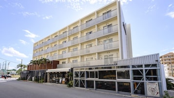 A multi-story hotel with balconies, a ground-level restaurant, and a visible entrance.