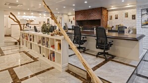 A modern reception area with a brick fireplace, a white tiled wall, and a wooden decorative piece.
