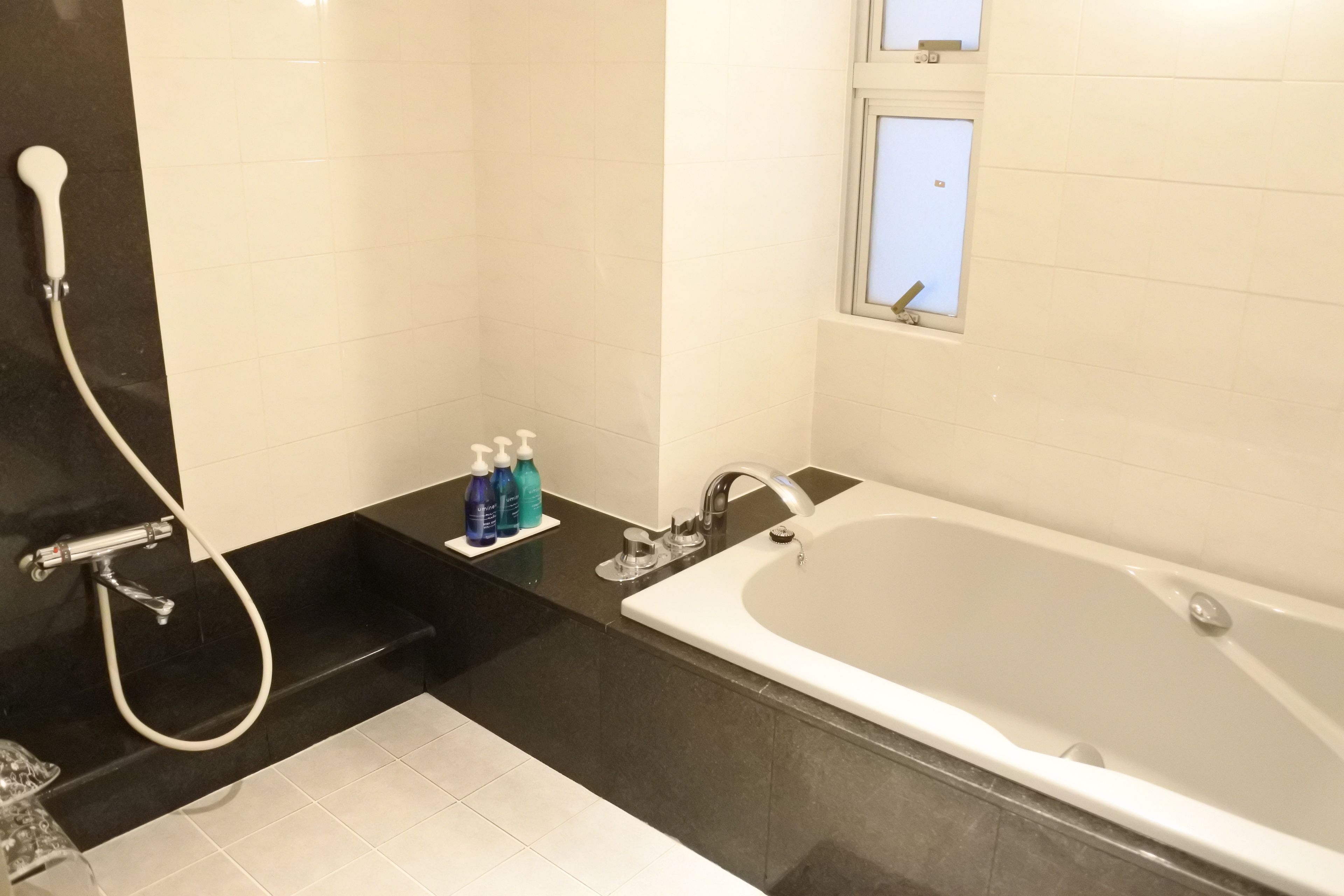 Un baño moderno con bañera, ducha y ventana.