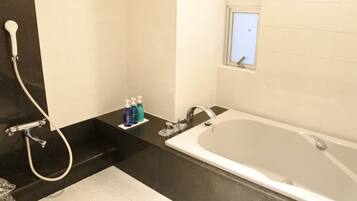 Un baño moderno con bañera, ducha y ventana.