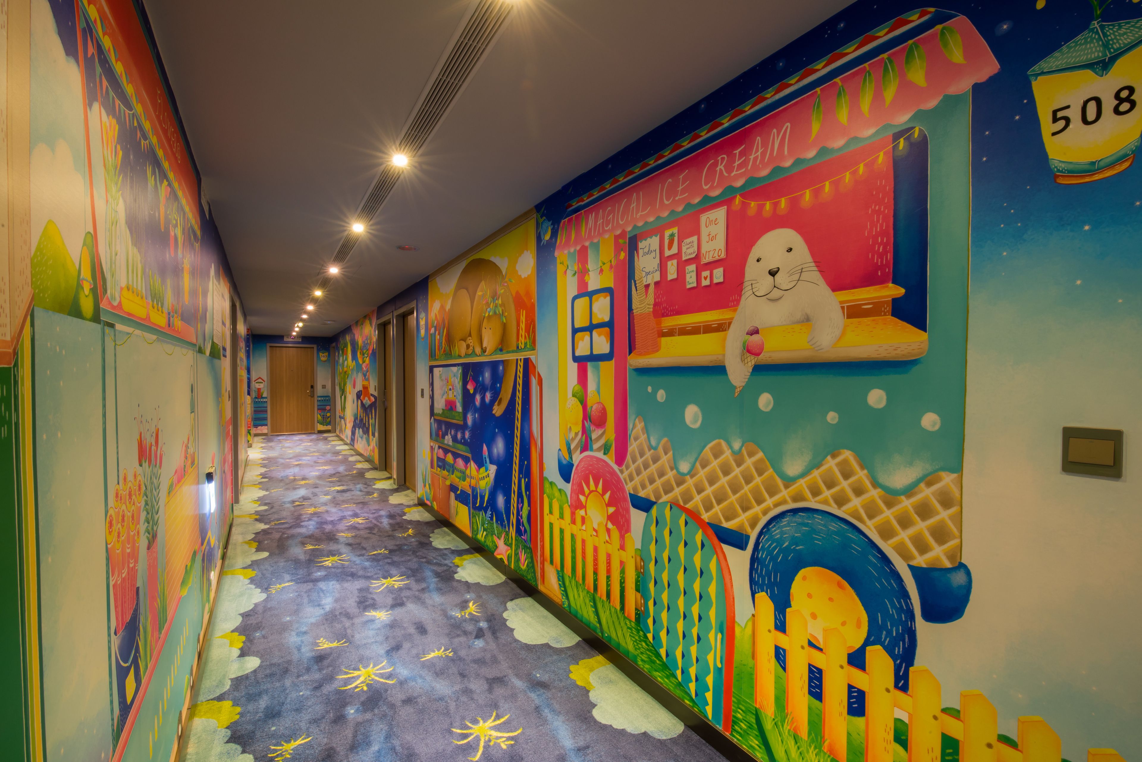A brightly decorated hallway with colorful murals, a whimsical ice cream shop illustration, and a starry carpet.