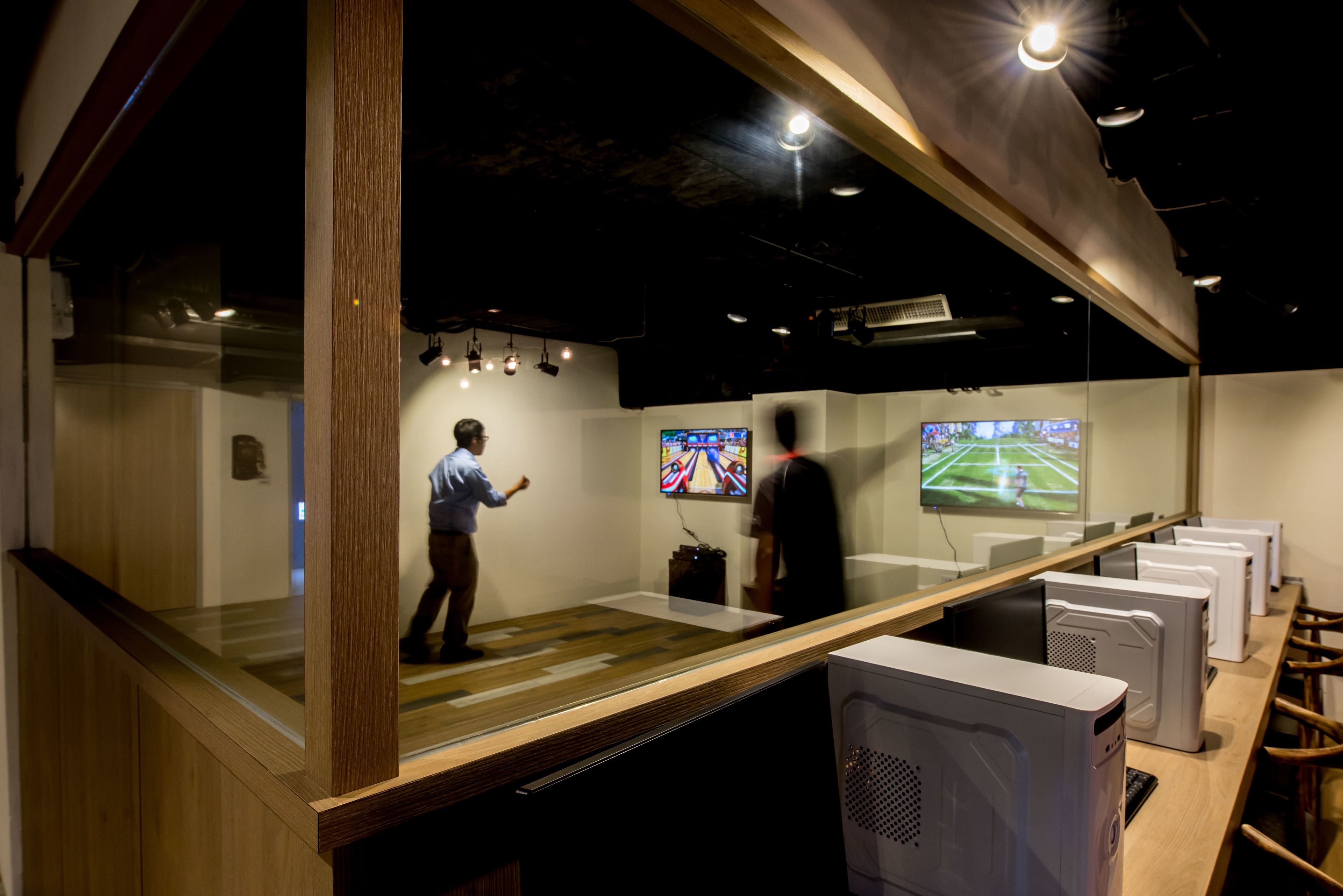 Un espace de jeux moderne agrémenté d’éléments en bois et doté de plusieurs postes de jeu.