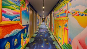 A brightly colored hallway with murals on the walls and a patterned floor. - Legend Hotel Pier 2 (Kaohsiung)