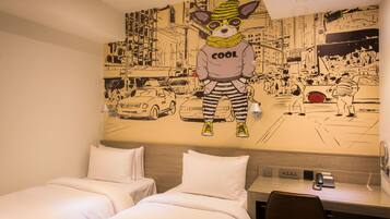 Een hotelkamer met twee bedden, een bureau en een muurschildering van een cartoonhond in een stadsgezicht.