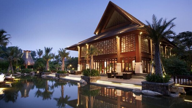 A resort with a large pool, wooden exterior, and tropical landscaping. - Shixishu Jianguo Yalong Bay Resort Hotel (Sanya)