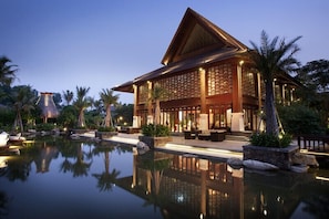 A resort with a large pool, wooden exterior, and tropical landscaping. - Shixishu Jianguo Yalong Bay Resort Hotel (Sanya)